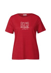 T-shirt rouge à manches courtes avec un col en V, présentant un design de texte blanc qui indique "ÉPURÉ PAR LE SOLEIL" à l'avant. Texture douce.