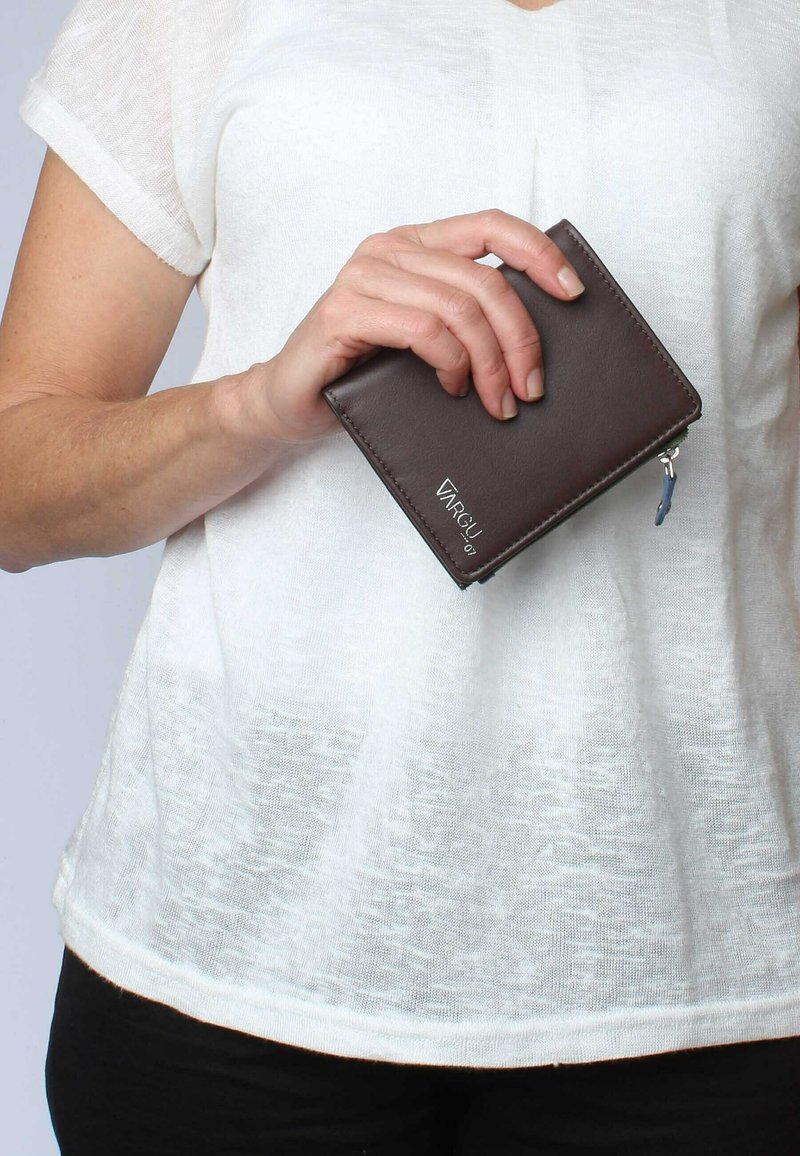 Brown leather wallet with a zip closure, rectangular shape, embossed brand logo, and a blue zipper pull. Held in a hand against a light background.
