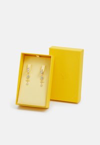 Gold-tone drop earrings featuring multiple clear crystals in a tiered design, presented in a yellow textured gift box with a lined interior.