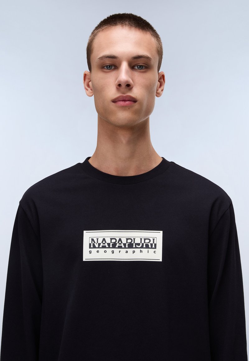 T-shirt nero a maniche lunghe in cotone con una grafica rettangolare bianca che presenta "NAPAPIJRI" e "geographic" in tipografia grassetto.