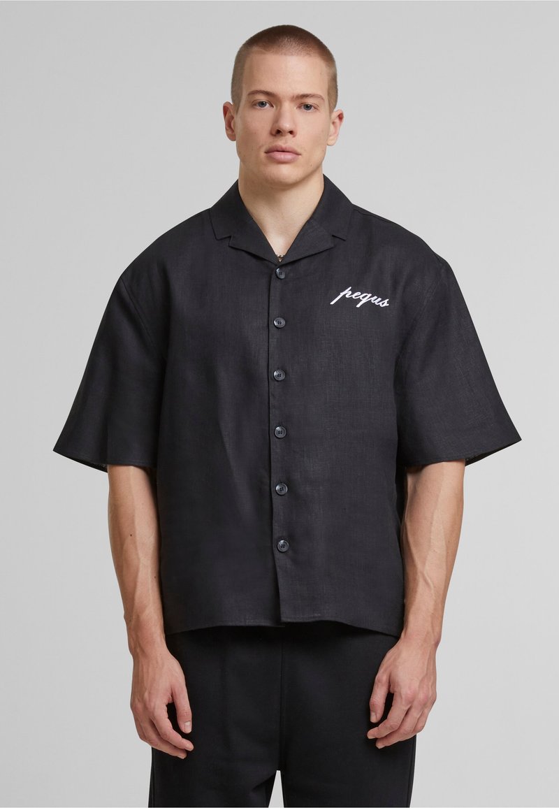 Black short-sleeve button-up shirt in a lightweight fabric, featuring a relaxed fit, a collar, and white embroidered text on the chest.
