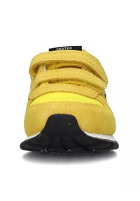 Sneaker giallo in velcro con tomaia in suede e rete, suola intermedia bianca e suola esterna in gomma nera. Presenta due cinturini in velcro nella parte anteriore.