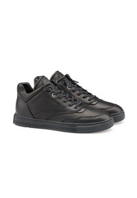 Zapatillas de cuero negro con un acabado suave, que cuentan con puntera redonda, cordones y suela de goma. El diseño incluye acentos mínimos y detalles de costura.