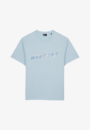 T-shirt en coton bleu clair avec des manches courtes et un col rond. Présente un texte en gras "QU'EST-CE QUE C'EST ?" dans un mélange de design graphique blanc et bleu.