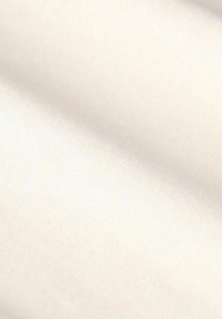 Tissu couleur crème avec une texture lisse et légèrement brillante, présentant de fins motifs de tissage, affichant des plis doux et des ombres subtiles.