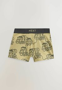 Beige bokser-shorts med sorte lastbilkonturer og -design, med en sort elastik med "NEXT" i guldbogstaver.