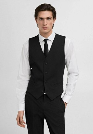 Schwarze taillierte Weste mit strukturiertem Design, fünf Knöpfen und zwei Seitentaschen, getragen über einem weißen Hemd und einer schwarzen Krawatte. Glatte Stoffbeschaffenheit.