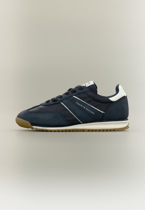 Sneakers blu navy realizzate con un mix di materiali in suede e sintetici, con dettagli bianchi e suola in gomma texturizzata. Marchio laterale.