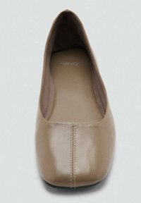 Zapato plano de cuero color topo con punta cuadrada y detalle de costura central, visto desde arriba sobre un fondo claro.