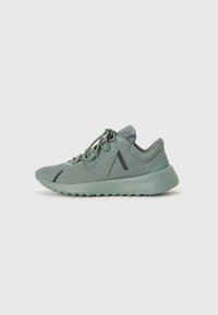 Zapatillas deportivas de color verde claro con parte superior de malla, superficie texturizada, diseño de cordones y una suela gruesa y acolchada. Presentan acentos negros mínimos.