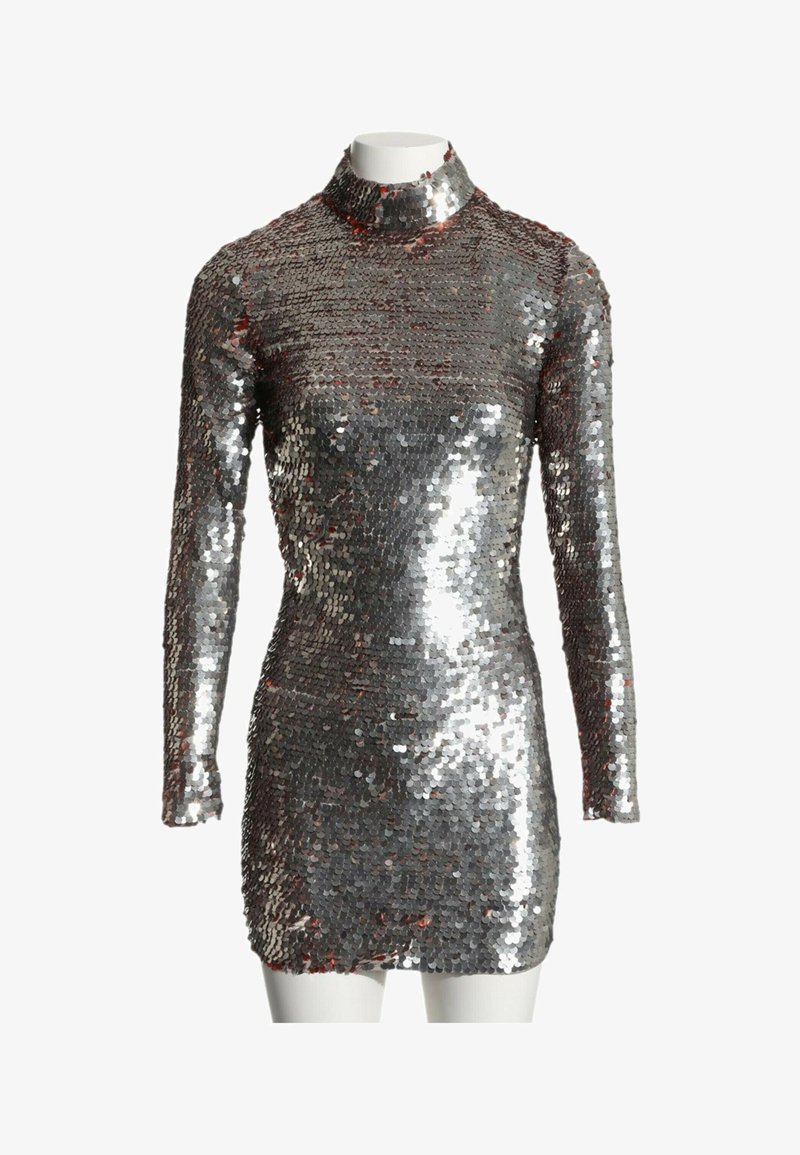 Mini-robe argentée à sequins, manches longues et col montant, exposée sur un mannequin blanc devant un fond uni.