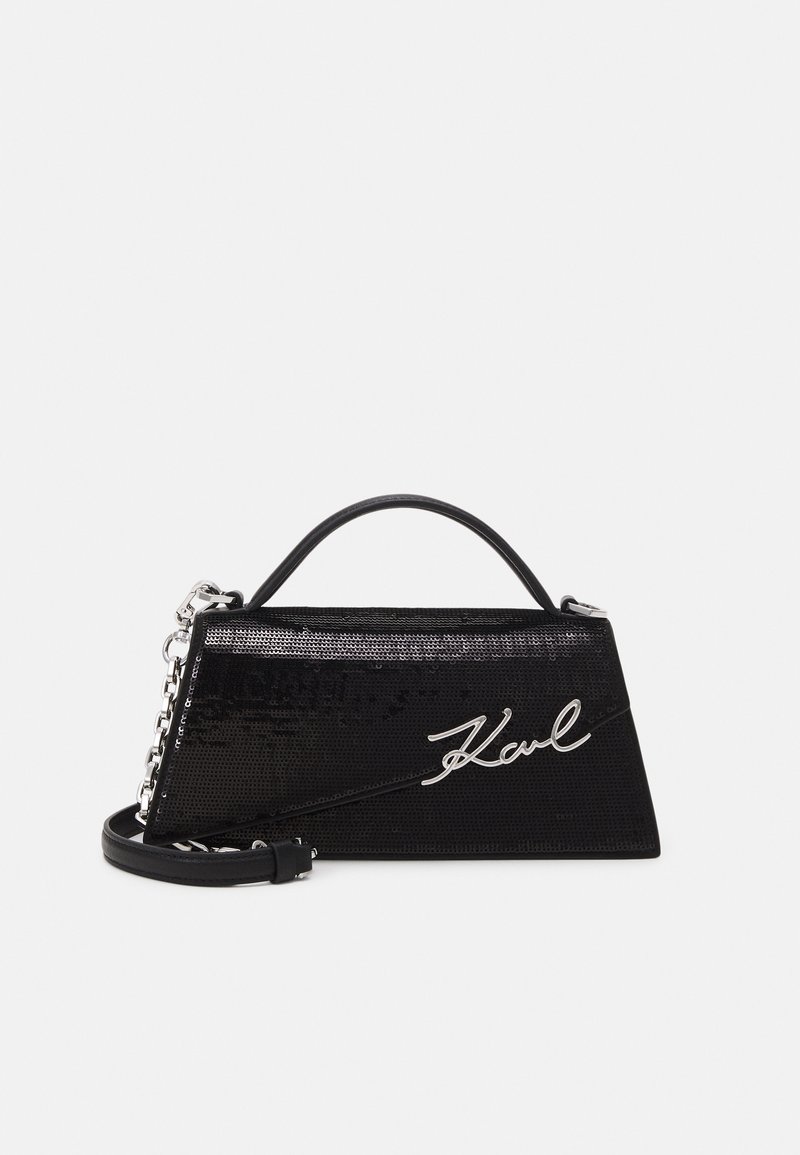 Sac à main trapèze noir avec sequins, bandoulière chaîne argentée, poignée supérieure et signature argentée ""Karl"" à l'avant.