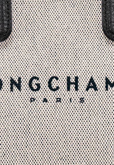Beige Canvas-Shopper-Tasche mit strukturiertem Muster, ausgestattet mit schwarzen Ledergriffen und geprägtem Logo mit der Aufschrift "LONGCHAMP PARIS."