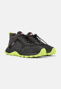 Czarne buty sportowe z teksturowaną cholewką, żywą, limonkową gumową podeszwą, elastycznymi sznurowadłami i czerwonymi akcentami marki na języku.