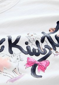Žaismingi juodi raštai su linksmomis katėmis aplink raides, su balta kate, rožine kaspinu ir mažomis rudomis dėmėmis ant balto fono.