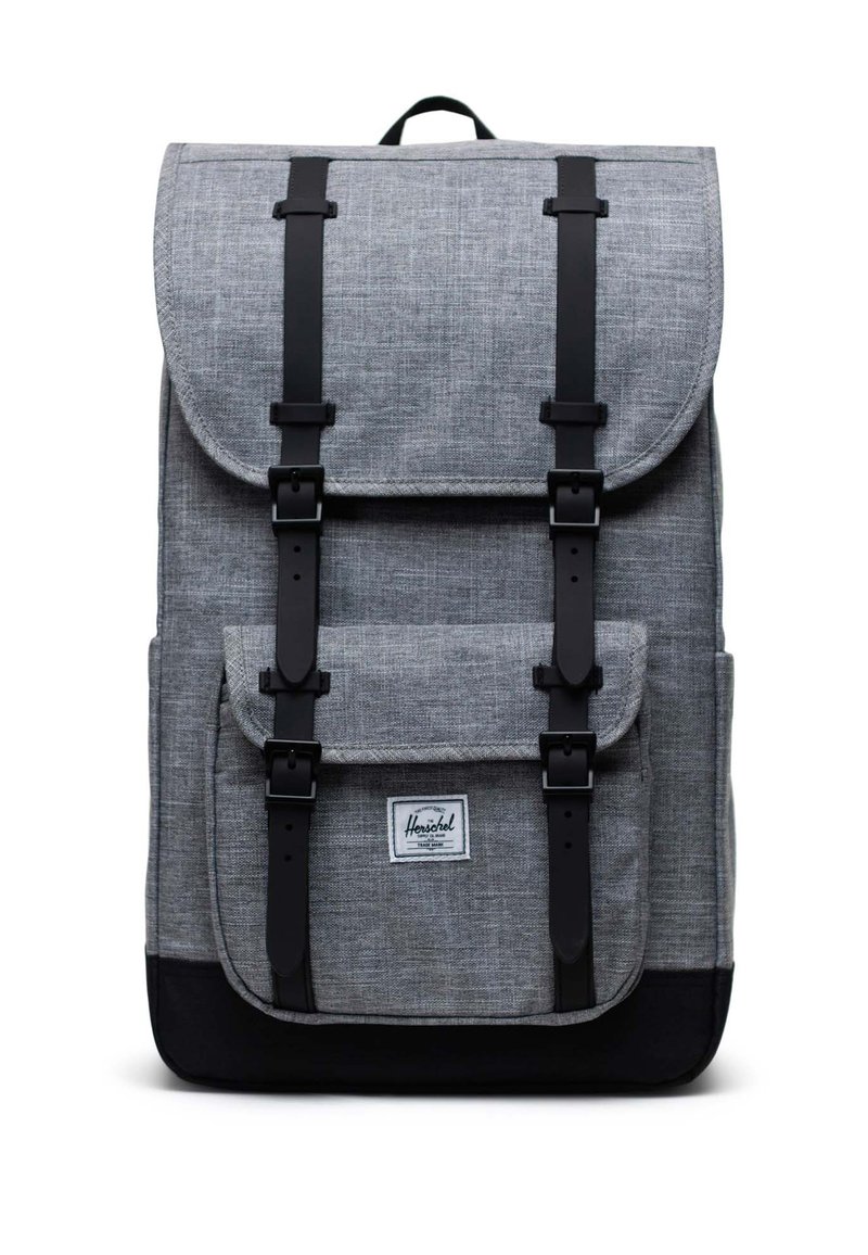 Sivý látkový batoh s čiernymi akcentmi, klopňové uzatváranie, nastaviteľné popruhy, predná vrecko a podpisová nášivka na dne.