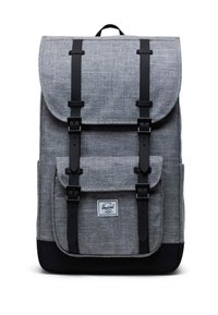 Harmaa kangaskassi mustilla yksityiskohdilla, läppäkiinnitys, säädettävät hihnat, etutasku ja tunnusläiskä alareunassa.