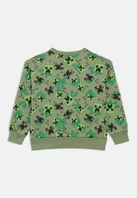 Zielona bluza z długim rękawem z nadrukiem na całej powierzchni przedstawiającym zielone pikselowane kostki i czarne pikselowane figury na jednolitym tle.