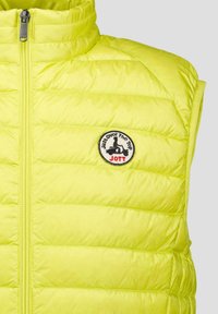 Limoengroene gewatteerde bodywarmer met hoge kraag, ritssluiting aan de voorkant en geborduurd embleem met de tekst "Just Over the Top" en "JOTT".