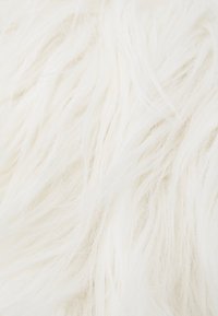 Biały sztuczny futerko z długimi, miękkimi włóknami, tworzące puszystą teksturę. Włókna są delikatne i luźno ułożone, co zwiększa miękkość.