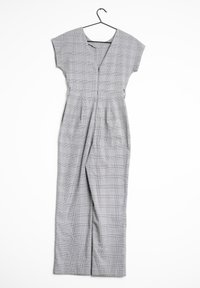 Szary, kratkowany kombinezon z krótkimi rękawami, dekoltem w serek i dopasowaną talią. Posiada elementy w pionie i boczne kieszenie dla większej funkcjonalności.