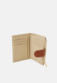 Portafoglio in pelle beige con più scomparti per schede, un compartimento con zip e una rifinitura in pelle marrone. Texture liscia con dettagli di cucitura discreti.