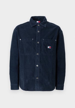 Marineblauwe corduroy overhemd met lange mouwen, knoopsluiting aan de voorkant, twee borstzakken en een klein logo-opkleefpatch op de linkerzak. Getextureerde stof.
