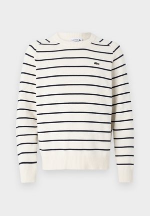 Suéter crema con rayas horizontales azul marino, con cuello y puños acanalados, que presenta un pequeño logo de Lacoste en el pecho. Corte clásico, textura de punto.