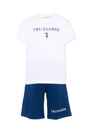 T-shirt bianca a maniche corte con scritta e logo "Trussardi" blu, abbinata a pantaloncini blu con scritta bianca "Trussardi" sulla gamba sinistra.