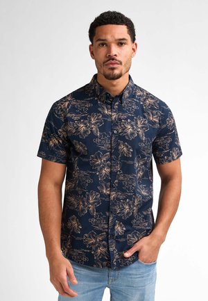 Camisa de manga corta en color azul marino con un patrón floral en beige. Cuello abotonado, tela ligera, con un corte regular y un diseño casual.