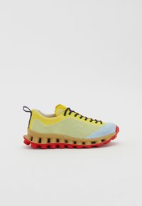 Knit sneakers with yellow and blue upper, rubber midsole in beige, and red outsole. Features black laces and a loop at the heel.