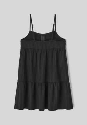 Robe noire sans manches avec un design à étages, présentant un tissu texturé et de fines bretelles. Le corsage est froncé avec un détail smocké.