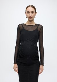 Fekete kismamaruha hosszú, áttetsző ujjakkal, finom csillogással, ráncolt derékrésszel és testhez simuló sziluettel, kör alakú nyakkivágással.