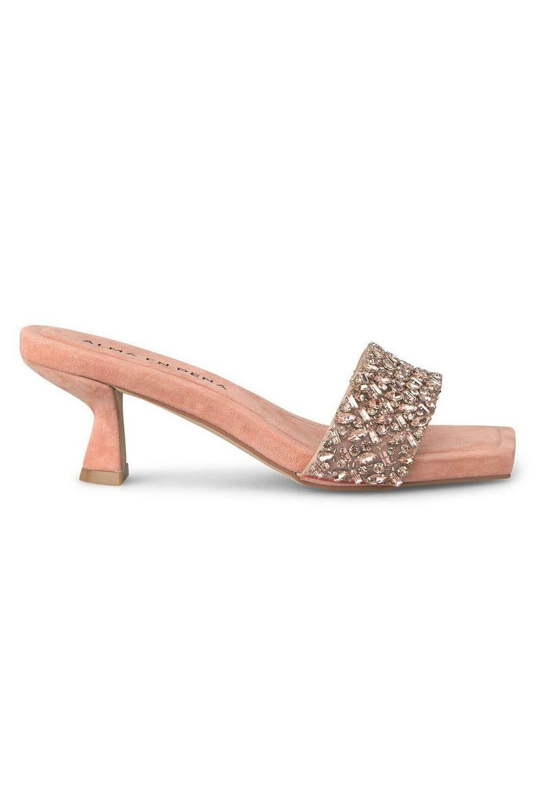 Sandalo rosa dorato con una fascia larga decorata con strass, tacco basso a blocco e materiale morbido simile al camoscio. Design con punta quadrata.