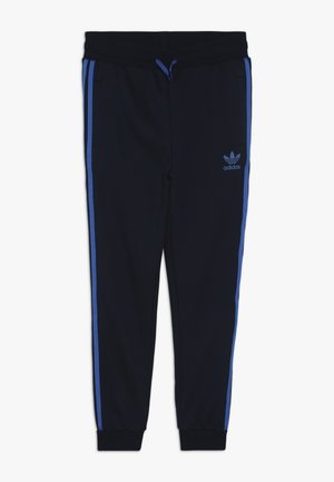 Czarne spodnie dresowe Adidas z niebieskimi bocznymi paskami, elastycznymi mankietami, paskiem ściągającym w pasie oraz logo Adidas trefoil na lewej udzie.