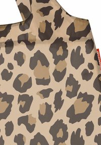 Leopard print fabric featuring a beige background with dark brown and light brown spots, smooth texture, and a curved top edge.