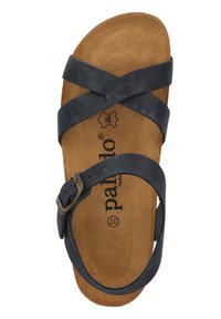 Sandalia de cuero negro con tiras cruzadas, hebilla ajustable y una plantilla de corcho texturizado en color marrón claro que presenta un logotipo de la marca.