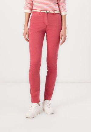 Red cotton blend pants with a slim fit, featuring a small belt, paired with white sneakers and a striped long-sleeve top.