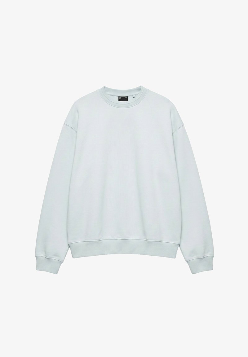 Sweat-shirt oversize bleu clair à col rond avec manches longues et poignets et ourlet côtelés, présenté sur fond blanc.
