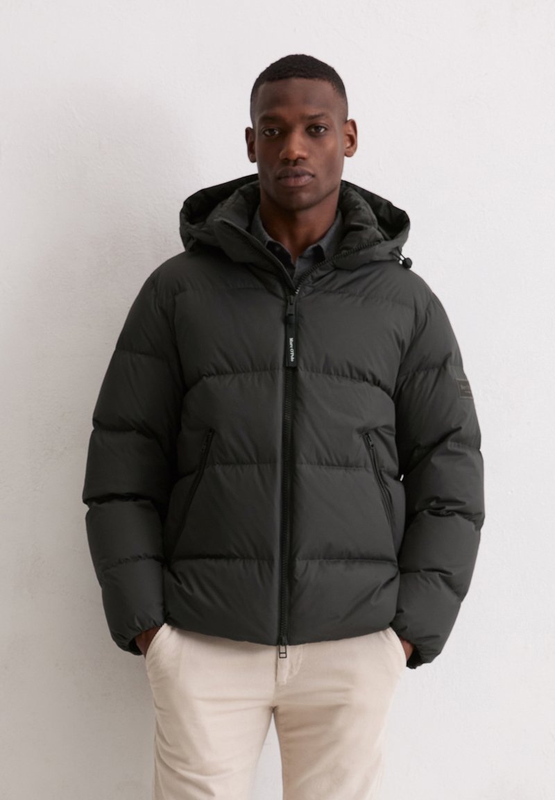 Czarna kurtka puchowa z kapturem, z przednim zamkiem błyskawicznym, poziomym pikowaniem oraz dwoma zamykanymi na zamek bocznymi kieszeniami. Nosi się ją na ciemną koszulę.