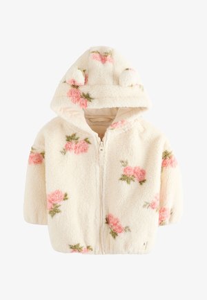 Krém színű, bolyhos baba dzseki rózsaszín virágmintákkal, elülső cipzárral és kapucnival, amelyen két kis anyagból készült fül található.