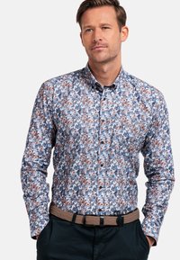 Chemise à manches longues avec un motif floral dans des tons de bleu, blanc et orange. Tissu en coton avec un col classique et des boutons noirs.