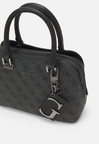 Schwarze synthetische Handtasche mit zwei Griffen, Reißverschluss, geprägtem Logomuster und einem Metallcharme mit einem großen 'G' als Akzent.