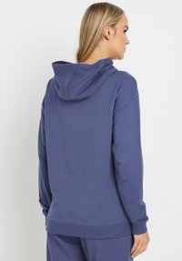 Marineblaue Kapuzenjacke aus weichem Material, mit einer Kordelzugkapuze, langen Ärmeln und gerippten Bündchen sowie Saum für eine lässige Passform.