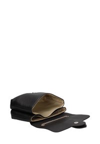 Borsa a mano in pelle nera con esterno testurizzato, aperta per rivelare un rivestimento interno beige e un comparto con zip. Dettaglio hardware circolare.
