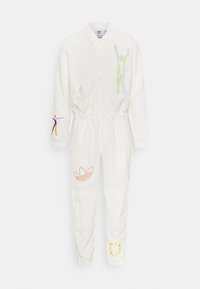 Witte jumpsuit met lange mouwen en kraag, elastische taille, kleurrijke abstracte menselijke figuren en gele tekstdetails op het onderbeen.