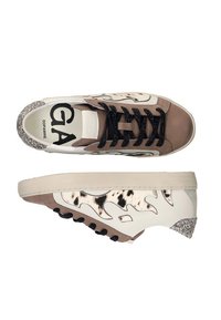 Zapatillas bajas que presentan una combinación de cuero beige y tejido con estampado, con cordones negros, un talón brillante y una superficie texturizada.