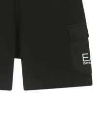 Pantaloni cargo neri con tasca a toppa e dettaglio logo bianco, caratterizzati da una texture di tessuto liscia e un design a taglio dritto.