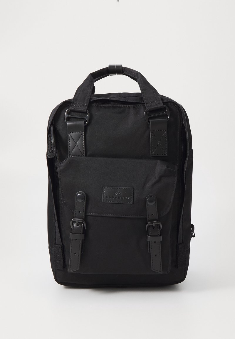 Sac à dos rectangulaire noir avec une poche avant sécurisée par deux sangles à boucle et des poignées supérieures visibles sur un fond uni.