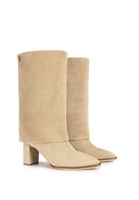Botas de tobillo de ante beige con tacón cuadrado, punta afilada y caña alta con costuras mínimas y un pequeño acento de logo.